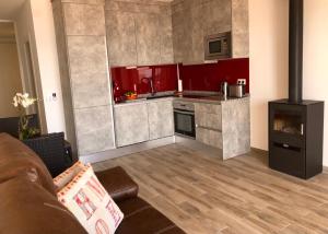 sala de estar con cocina con armarios rojos en Calahonda Beach Apartments, en Sitio de Calahonda