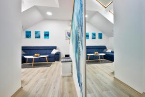 Križevci的住宿－Florek & Florica Apartment，客厅设有蓝色的沙发和冲浪板