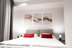 two beds in a bedroom with two red pillows at SAVOY residence&spa in Osijek
