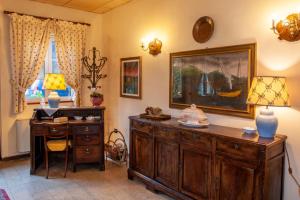 盧卡的住宿－美勒奇酒店，一间设有书桌的客房,墙上挂有绘画作品