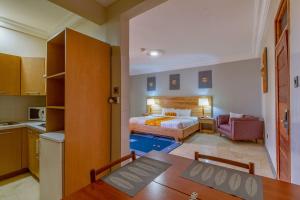 a kitchen and a bedroom with a bed and a table at Central Hotel - OSU in Accra