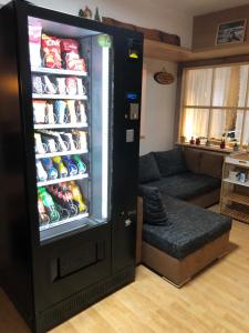 um grande frigorífico preto com bebidas numa sala de estar em Gästehaus am Kurparkweg em Reit im Winkl