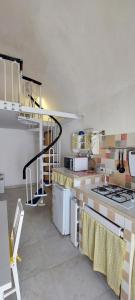 a kitchen with a stove and a spiral staircase at Casa Daniela 2 in Vieste
