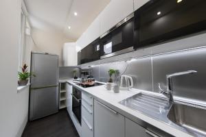 a kitchen with a sink and a refrigerator at Spacious 3-room apartment with free parking in Budapest