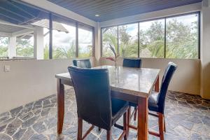 a dining room with a table and blue chairs at Waimea at Morningstar Breeze Gold Standard Certified in Hopkins