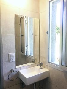 a bathroom with a sink and a mirror and a window at Cabañas Sonnenblumen in Potrero de Garay