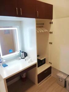 baño con encimera blanca y lavamanos en NutriTECH Hotels & Events, en Calapan