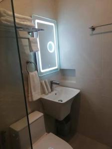 a bathroom with a sink and a toilet and a mirror at NutriTECH Hotels & Events in Calapan