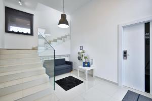 uma sala de estar com escadas e um sofá azul em Florek & Florica Apartment em Križevci