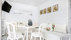 a white dining room with a white table and chairs at Anc 13 BP - Llafranc in Calella de Palafrugell