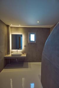 a bathroom with a sink and a mirror at Coco-Mat Hotel Santorini in Akrotiri