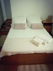 a large bed with white sheets and pillows on it at Guesthouse Gligora in Mandre