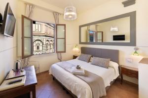 フィレンツェにあるB&B ソッジョルノ バティステロのベッドルーム(ベッド1台、大きな鏡付)
