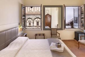 - une chambre avec un grand lit et un miroir dans l'établissement B&B Soggiorno Battistero, à Florence