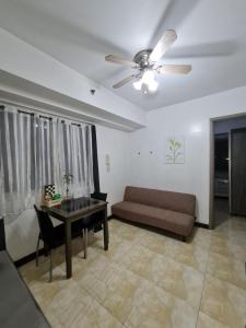 a living room with a couch and a ceiling fan at Solemare Parksuites Condominium - Condo R Us in Manila
