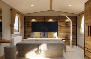 a bedroom with a large bed with a blue headboard at Whitecliff Bay Holiday Park in Bembridge