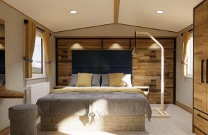 Schlafzimmer mit einem großen Bett mit blauem Kopfteil in der Unterkunft Whitecliff Bay Holiday Park in Bembridge