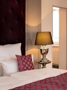 a bedroom with a bed and a lamp on a table at Boardinghouse Rathsmühle in Aachen