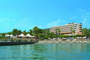 um resort com cadeiras e guarda-sóis e um edifício em Elias Beach Hotel em Limassol