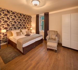 a bedroom with a bed and a chair at Boardinghouse Rathsmühle in Aachen