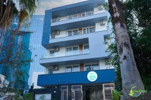 un edificio azul con un árbol delante de él en Lime Tree Hotel Near 32nd Avenue Sector 29 Gurgaon, en Gurgaon