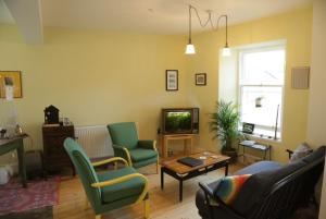 un soggiorno con divano, sedie e TV di The Dolphin Inn Hostel a Dunbar