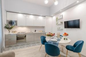 a kitchen with a table and blue chairs at Casa Versilia Style in Viareggio