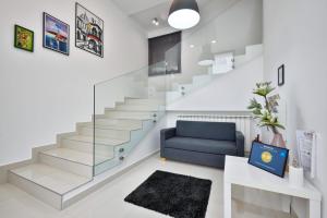 uma sala de estar com escadas e um sofá azul em Florek & Florica Room001 em Križevci