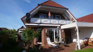 ein Haus mit einer Veranda und einem weißen Stuhl in der Unterkunft Ferienwohnung Amanda 1 in Bad Zwischenahn