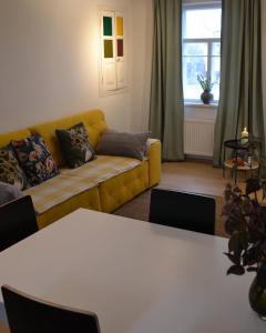 a living room with a yellow couch and a table at SynytsVille in Sinitsa