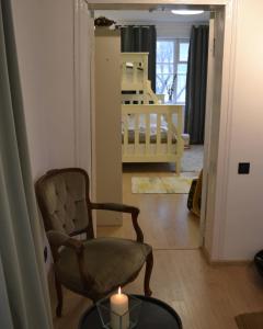 una sala de estar con una silla y una vela sobre una mesa en SynytsVille, en Sinitsa
