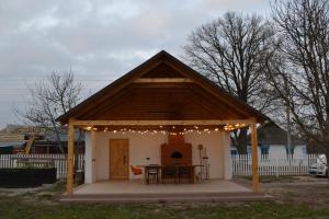 a gazebo with a table and chairs and lights at SynytsVille in Sinitsa