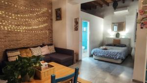 a living room with a couch and a bed at Triana Boho Chic WiFi in Seville