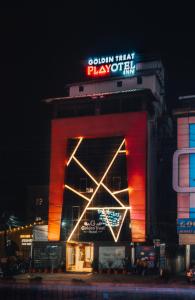 a building with a sign on top of it at night at Playotel Inn Golden Treat in Indore