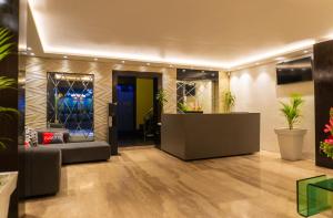 a lobby with a waiting area with a couch and plants at Hotel Golden Treat in Indore