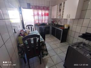 a kitchen with a table and chairs and a stove at APARTAMENTO PIUMA in Piúma