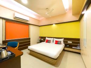 a hotel room with a bed and a desk and a kitchen at Playotel Inn Golden Treat in Indore