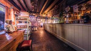 un bar con una estatua sentada en un mostrador de madera en The Sheppey, en Glastonbury