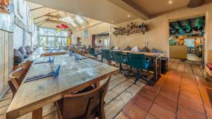Un restaurante con mesas y sillas de madera en una sala. en The Sheppey, en Glastonbury