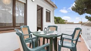 a green table and chairs on a patio at 1Blan - Llafranc in Llafranc