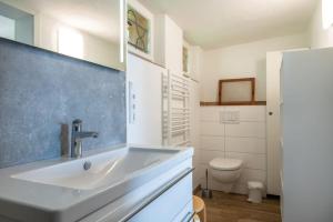 a white bathroom with a sink and a toilet at Haus am Hügel in Groß Zicker +19 photos