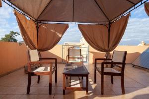 un patio avec des chaises, une table et un parasol dans l'établissement Buhardilla Nuria, à Carthagène