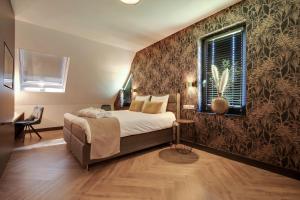 a bedroom with a bed and a wall with wallpaper at Op dn Kreijtenberg in Milheeze