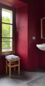 ein rotes Zimmer mit einem Tisch und einem Fenster in der Unterkunft Le Macine del Perino in Bettola