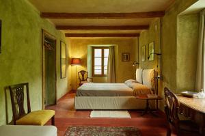 1 dormitorio con 2 camas, mesa y ventana en Le Macine del Perino, en Bettola