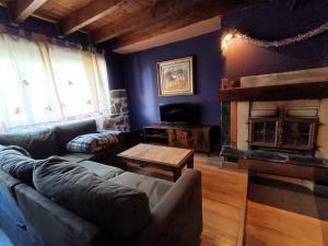 ein Wohnzimmer mit Couch und Kamin in der Unterkunft La Casita Violeta in Santa María de la Alameda