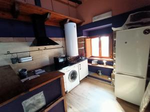 eine Küche mit einem Kühlschrank und einer Waschmaschine in der Unterkunft La Casita Violeta in Santa María de la Alameda + 3 Fotos