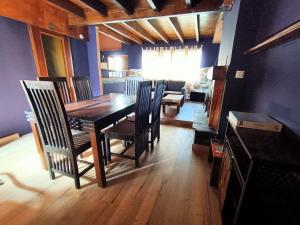 a dining room with a wooden table and chairs at La Casita Violeta in Santa María de la Alameda