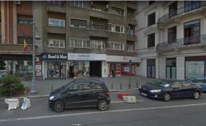 two cars parked on a street in front of a building at MONOCHROME MAGIC. Calea Victoriei Studio in Bucharest