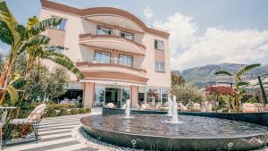 a building with a fountain in front of a building at Sole Luna Hotel in Borsh
